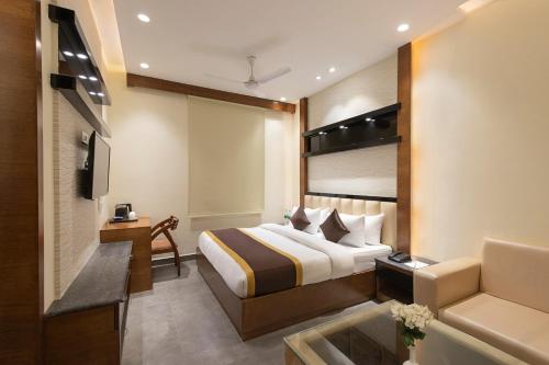 una habitación de hotel con una cama y un sofá en Clarks Collection Maanya, en Bareilly