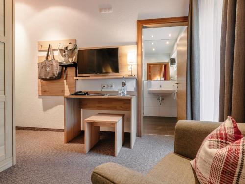 a hotel room with a desk and a chair at Alpinhotel Monte Superior - Silvretta Card Premium Betrieb in Galtür