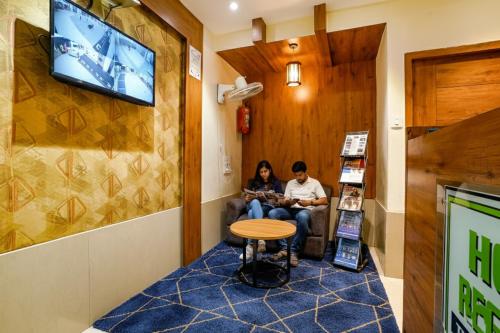 a man and a woman sitting in a waiting room at FabHotel Regal Inn - In Sahar Road in Mumbai