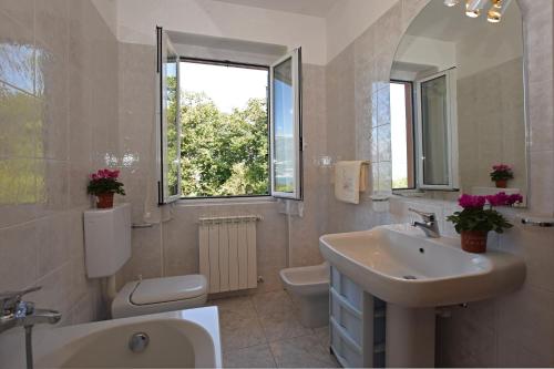 a bathroom with a sink and a toilet and a window at Viola in Colico