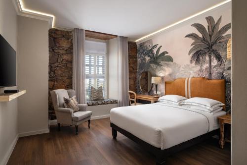 a bedroom with a large white bed and a chair at Protea Hotel by Marriott Mossel Bay in Mossel Bay