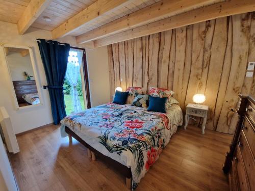 une chambre avec un lit dans une pièce aux murs en bois dans l'établissement Le Ptit Nid Sous le Chêne, à Xamontarupt