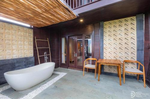 a bathroom with a tub and a table and a desk at Munduk Kupang Sekumpul Villa in Singaraja