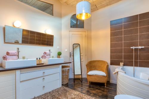 a bathroom with a tub and a sink and a mirror at Calmacé in Gignac