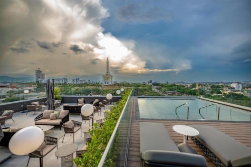 a rooftop patio with chairs and a pool on a building at Hotel Hampton By Hilton Santiago De Los Caballeros in Santiago de los Caballeros