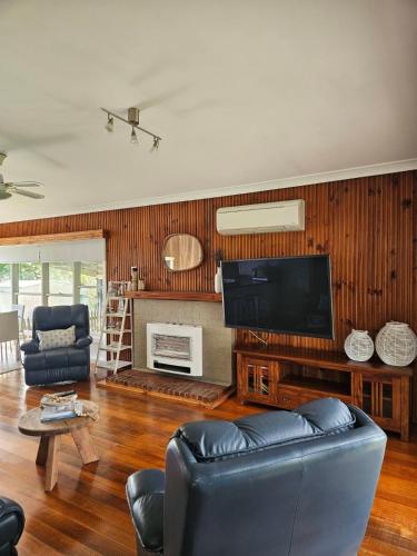 a living room with a couch and a flat screen tv at Port Sorell Beach Shack in Port Sorell
