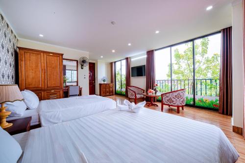 a large bedroom with two beds and a balcony at Thu Ha Hotel in Uông Bí