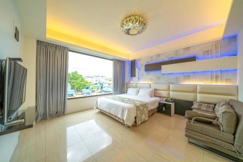 a bedroom with a bed and a couch and a tv at 蘭庭 Villa民宿 B&B in Yuanshan