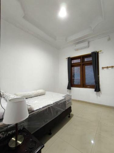 een slaapkamer met een bed en een raam bij Daffodil House Proper Guest House Near Malioboro in Demangan