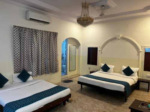 a hotel room with two beds and a chandelier at Crown Plaza Heritage in Jodhpur