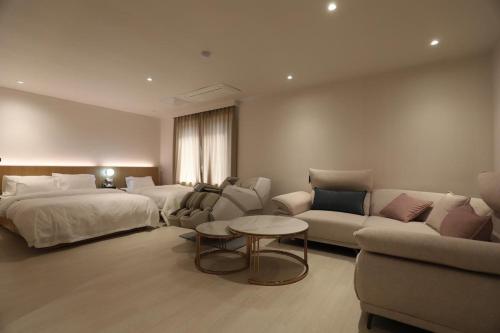 a hotel room with two beds and a couch at Hotel Boreum in Sach'ŏnjil-li