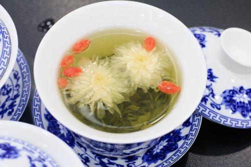 a bowl of soup on a table with blue and white plates at Dojo Hostel in Chiang Mai