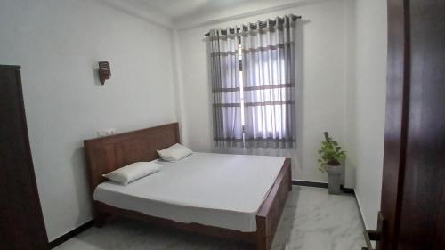 ein Schlafzimmer mit einem weißen Bett und einem Fenster in der Unterkunft Luna Villa in Mawadawila