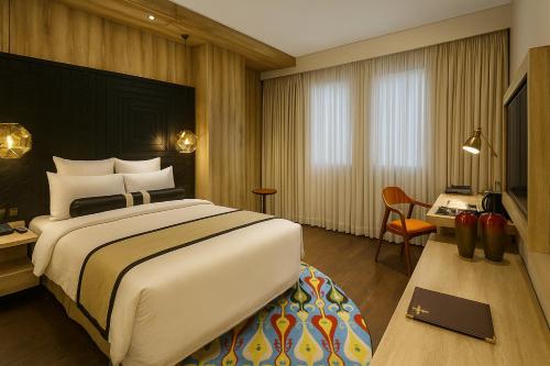 a hotel room with a large bed and a desk at HOTEL dGATES in Lahore
