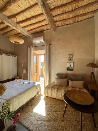 a bedroom with a bed and a couch and a table at Dar faracha in Ouarzazate