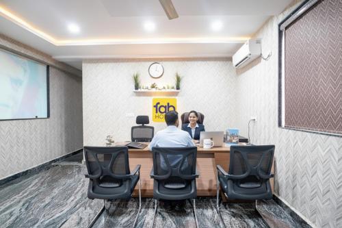 two people sitting at a table in a meeting room at FabHotel Frendz - Nr Hitech City Metro Station in Jāmb