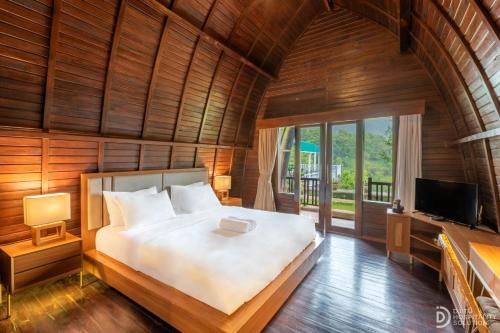 a bedroom with a large bed and a tv at Munduk Kupang Sekumpul Villa in Singaraja