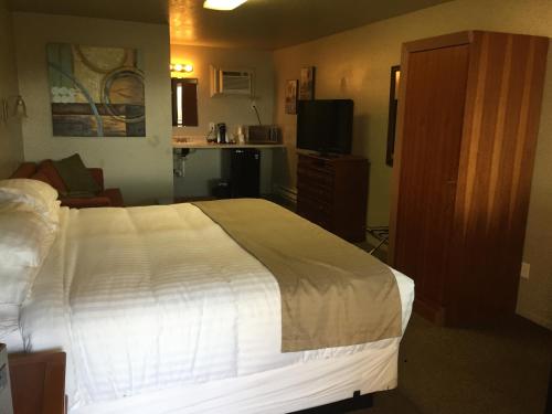 a bedroom with a large white bed and a television at Gateway Inn in Lyman