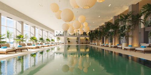 einen großen Pool in einer Hotellobby mit Stühlen in der Unterkunft Iberostar Selection Montenegro in Topolica