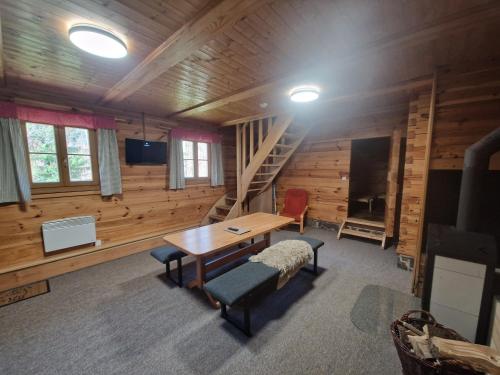 uma sala com uma mesa e cadeiras e uma escada em Chalupa Pod lomem - Malá em Dolní Morava