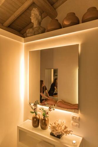 a mirror on a wall with two people in a room at Palazzo Lecce - Epoca Collection in Lecce
