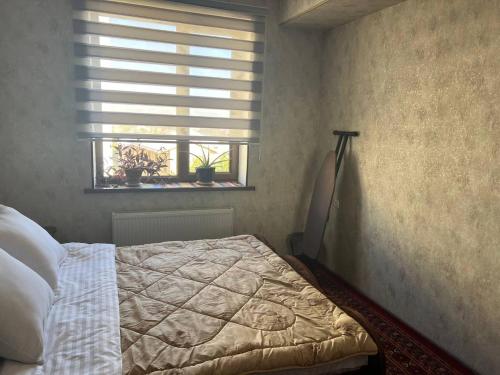 a bedroom with a bed and a window at Квартира Комфорт in Samarkand
