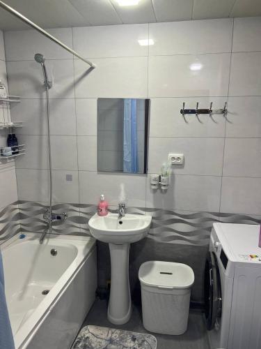 a bathroom with a sink and a toilet and a bath tub at Квартира Комфорт in Samarkand