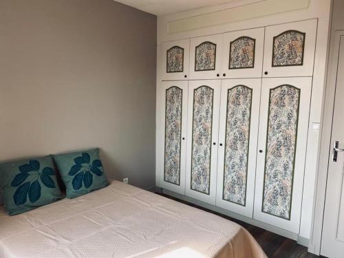 a bedroom with a bed and a wall with windows at Gite Pomme de pin in Almenêches