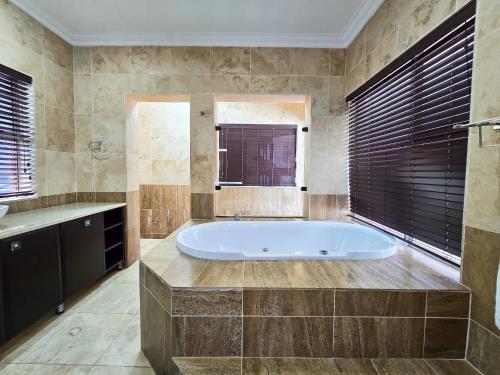 un ampio bagno con vasca e finestra di On The Moon Hospitality and Conference Facility a East London