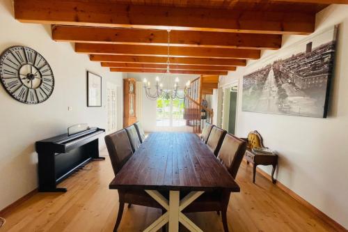 une salle à manger avec une table en bois et un piano dans l'établissement Villa paisible avec piscine, à Bercloux