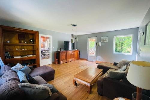 un salon avec deux canapés et une table basse dans l'établissement Villa paisible avec piscine, à Bercloux