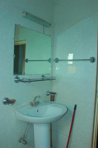 a white bathroom with a sink and a mirror at Mount heaven Hotel in Murree