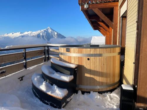a hot tub on the roof of a house in the snow at Hotel Zeit & Traum Privat SPA in Beatenberg