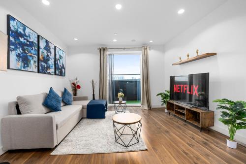 a living room with a couch and a tv at Panoramic City Views Elegant 2BR, 2 Min to Metro in Manchester