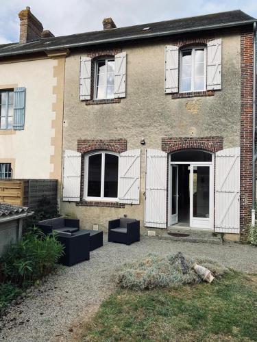 a brick house with windows and a courtyard at Gite Pomme de pin in Almenêches