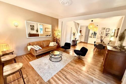 a living room with a couch and a table at Maison Arcania Raw Charm & Secret Garden in Reims