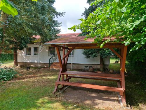 a wooden picnic table in front of a house at Bungalow 2 - 4-Raum-Wohnung mit Küche und 2 WC Duschen in Ohrdruf-Crawinkel in Niederdorla