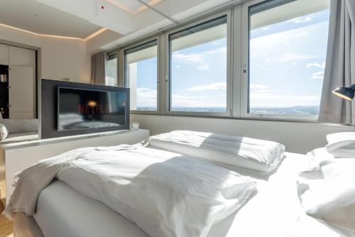 a bedroom with a bed and a flat screen tv at Luxury City Apartment with Skyline View in Vienna
