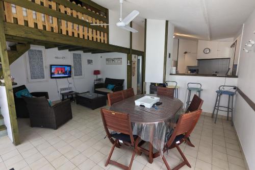 a living room with a table and chairs and a kitchen at Spacious nest with terrace near the beach in Talmont-Saint-Hilaire