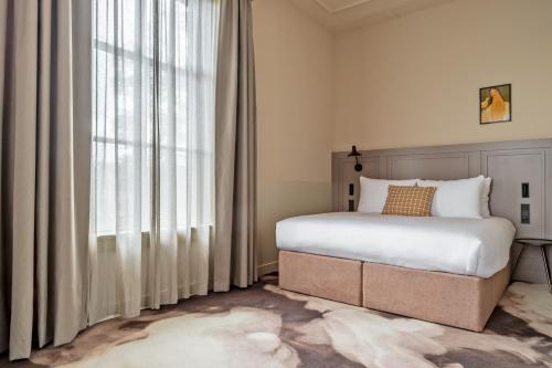 une chambre avec un lit et une grande fenêtre dans l'établissement Metzlr House, à Haarlem