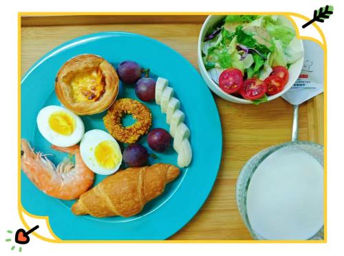 um prato azul com ovos, pão e salada em Hando • Cape Seven Seaside Villa em Qingdao