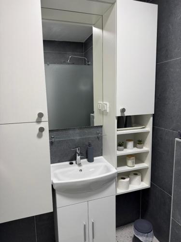 a white bathroom with a sink and a mirror at Kuća za odmor Stubaki in Stubicke Toplice