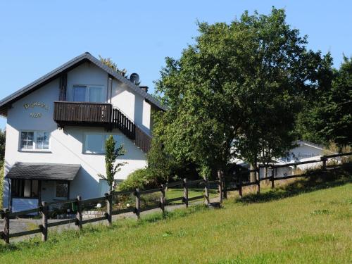 a white house with a fence in front of it at Dümpelhof Ferienwohnungen in Olsberg