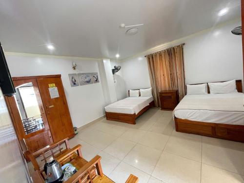 a hotel room with two beds and a television at Manh Vuong Hotel &Travel in Cat Ba