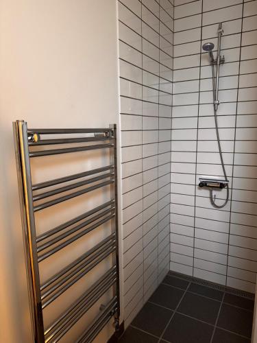 a shower in a bathroom with white tiles at Jysk bed and no breakfast in Ikast