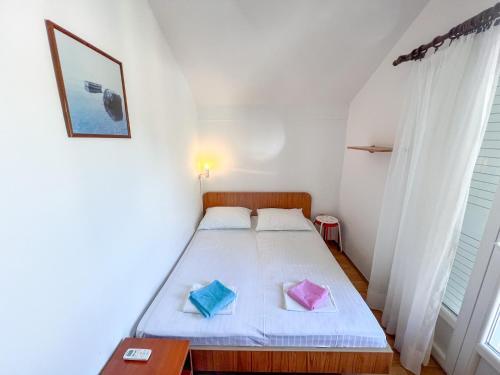 een slaapkamer met een bed met twee kussens erop bij Apartments Adna in Podaca