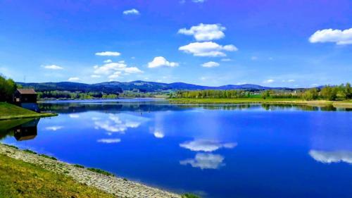 a large blue lake with clouds in the sky at Ferienwohnung Herzmensch in Tiefenbach