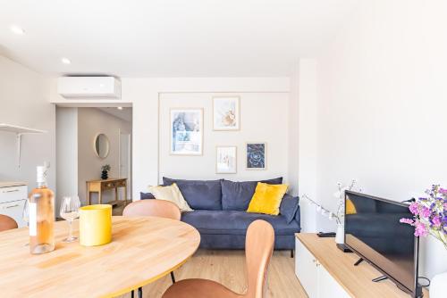 a living room with a blue couch and a table at AK Magnifique et spacieux 3 pièces, vue mer in Antibes