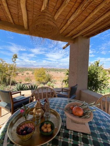 a table with a bowl of fruit on top at Dar faracha in Ouarzazate