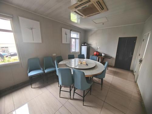 a dining room with a table and blue chairs at Suhe Homestay in Nanjing